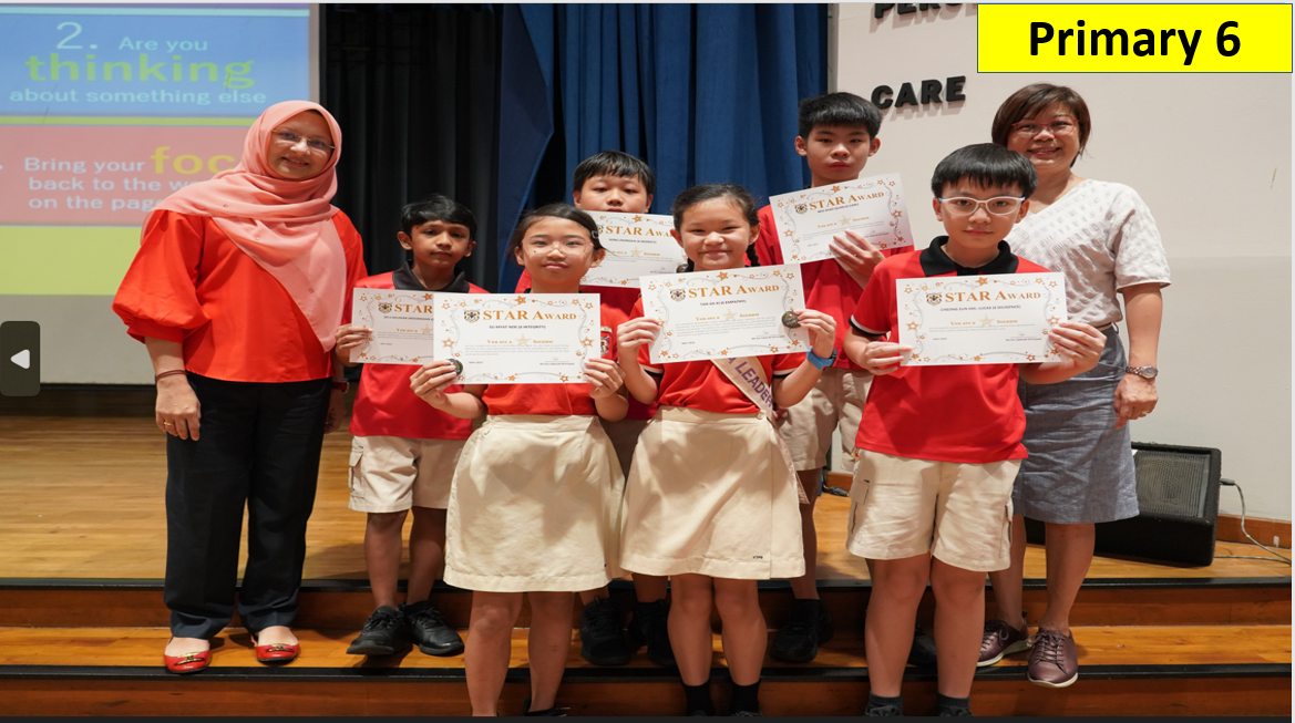 Six Primary 6 students in red uniforms hold Star Award certificates on stage, flanked by two adult teachers.